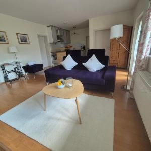 a living room with a couch and a table at Ferienwohnung Dorn in Lautertal +8 photos