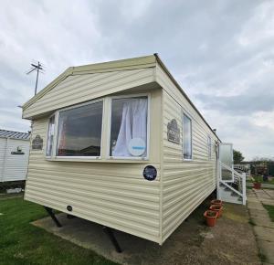 a small caravan with a window in a yard at 3 Bed Standard caravan Robinhood in Rhyl