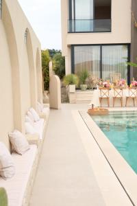a resort pool with white pillows next to a building at Villa Escape 21 in Durrës
