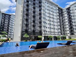 a woman laying in a chair in front of a building at DreamEscape by Charm Residences in Manila