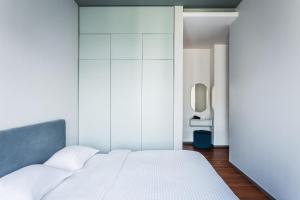 a bedroom with a white bed and a mirror at Boulevard 115 in Tashkent