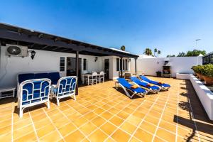 un patio con sillones azules y una casa en Luxury House Tiati, en Tías