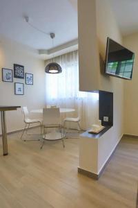 a living room with a table and chairs and a tv at Modern near the sea-Sunset View Apartments in Ixia