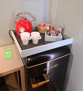 a counter with cups and a tea kettle on top of a refrigerator at Hostal Luxury Green Madrid Gran Vía in Madrid