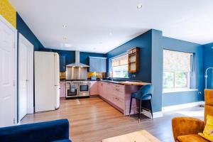 a kitchen with blue walls and a white refrigerator at Spacious Comfort for Contractors & Long-Term Guests in Saighton