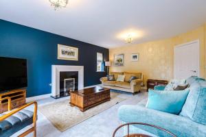 a living room with a couch and a tv at Spacious Comfort for Contractors & Long-Term Guests in Saighton