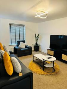 a living room with a couch and a tv at 4-Bed Charming Pet-Friendly House w Garden in Peterborough