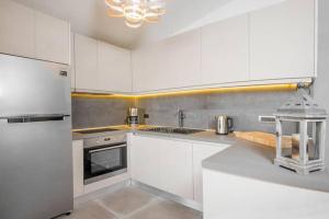 cocina blanca con armarios blancos y nevera en Sea View-Sunset View Apartments, en Ixia