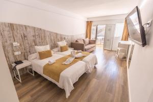 a bedroom with a large bed and a living room at BQ Cala Ratjada in Cala Ratjada
