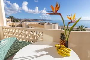 a vase with a bunch of bananas on a table with a pineapple at R2 Maryvent Beach Apartments in Costa Calma
