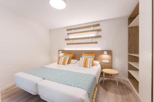 a white bedroom with a bed and a table at R2 Maryvent Beach Apartments in Costa Calma