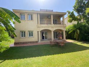 a house with a table and chairs in the yard at Modern Villa in Madinaty