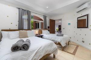 タマリンドにあるNax3 Luxury Condo in Upscale Langosta Communityのタオルが敷かれたベッドが2つある寝室 +11枚の写真