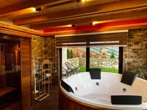 a large bath tub in a room with a large window at Gorska Vila BB in Bajina Bašta