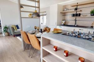a kitchen and dining room with a counter and a table at Pebble Beach Resort The Goodwood Lodge in Kinmel Bay