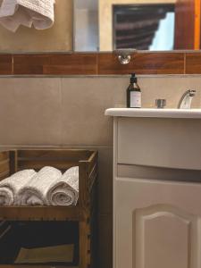 a bathroom with a sink and a towel rack with towels at Huaco Casa de Campo in Belén