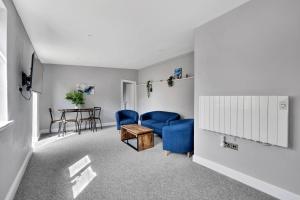ノリッジにあるStylish & Cosy 2BR Ensuite Condo with Parkingの青い椅子とテーブルのあるリビングルーム