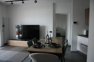 a dining room with a table with chairs and a television at ferienwohnungkarlena in Cerro Lago Maggiore