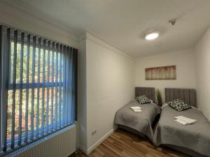 duas camas em um quarto com uma janela grande em MK Apartments, City of Manchester, Chorlton em Manchester mais 15 fotografias
