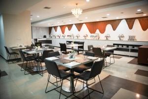 ein Speisesaal mit Tischen und Stühlen in einem Restaurant in der Unterkunft Heritage Residency By Lemongrove Hospitality in Madurai