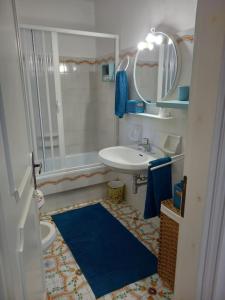 a bathroom with a sink and a toilet and a mirror at Chalet Felicita con giardino Immerso nel bosco in Castellaneta Marina 