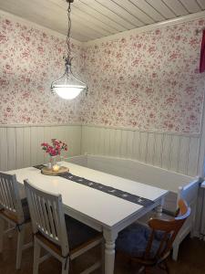 a dining room with a table and flowers on the wall at Room Sebi in Arvidsjaur +6 photos