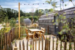 a wooden table and chairs next to a fence at Les Nuits de Thoiry in Thoiry