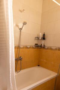 a bathroom with a bath tub with a shower at 2 Bedroom Terrace apartment with High speed internet in Sheikh Zayed +17 photos