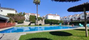 a swimming pool in front of some houses at Apartamento Villa Rizos in Mairena del Aljarafe