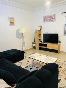 Una sala de estar con un sofá y un televisor de pantalla plana. en MDI Résidence officiel, en Abiyán