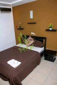 Un dormitorio con dos camas y un reloj en la pared. en MDI Résidence officiel, en Abiyán