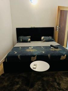 Un dormitorio con una cama con una mesa al lado. en MDI Résidence officiel, en Abiyán