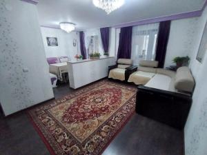 a living room with a couch and a rug at Трешка микрорайон Саулет 11 in Qyzylorda