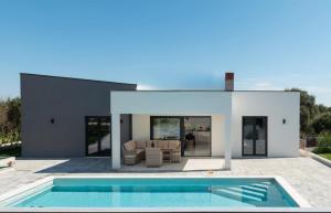 a house with a swimming pool in front of it at Villa Mateo 2 in Ližnjan