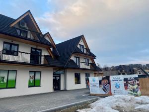 ein Haus mit Schildern davor in der Unterkunft Folkova 21 - Apartamenty in Biały Dunajec