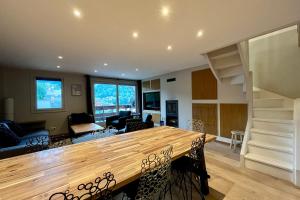 a kitchen and living room with a large wooden table at Lachat 15 in Mussillon