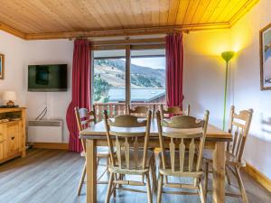een eetkamer met een tafel en stoelen en een raam bij Appartement familial - 2 chambres, balcon, proche pistes, Méribel - FR-1-355-96 in Méribel