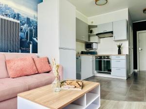 a living room with a pink couch and a table at Apartamenty A&M in Stargard