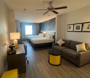 サンアンジェロにあるComfort Suites San Angelo near Universityのベッドとソファのある広いホテルの部屋