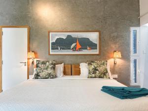 a bedroom with a bed and a painting on the wall at Blue Bird in Pereybere