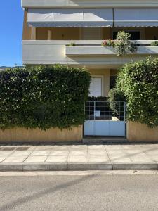 a building with two bushes next to a sidewalk at PATIMA Chalandri House in Athens