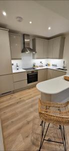 a kitchen with a white table and a white counter top at Stylish new 2 bedroom apartment in London