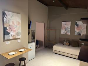 a room with a bedroom with a bed and a table at Mambuca Village in Ubatuba