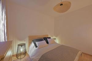 una camera da letto con un letto e una lampada di Emile - Apt avec Clim intra muros ad Avignone