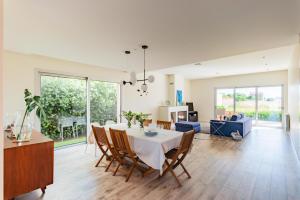 a dining room and living room with a table and chairs at Villa Joana - Moradia premium em Aveiro in Esgueira