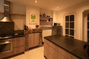 a large kitchen with wooden cabinets and black counter tops at Huis Agnes in Ostend