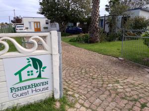 a sign for a guest house in a driveway at Fisherhaven Guest House in Hermanus