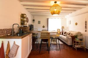 a kitchen and living room with a table and a couch at LE NID - Maison d'invités in Saint-Lucien
