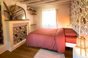 a bedroom with a bed and a fireplace at LE NID - Maison d'invités in Saint-Lucien