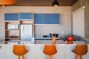 a kitchen with orange chairs and a white refrigerator at Chalés Rancho Queimado in Rancho Queimado